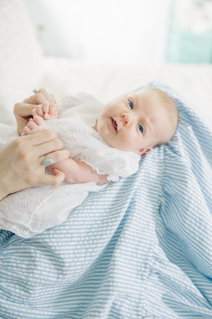 a 6 week old baby in a white dress