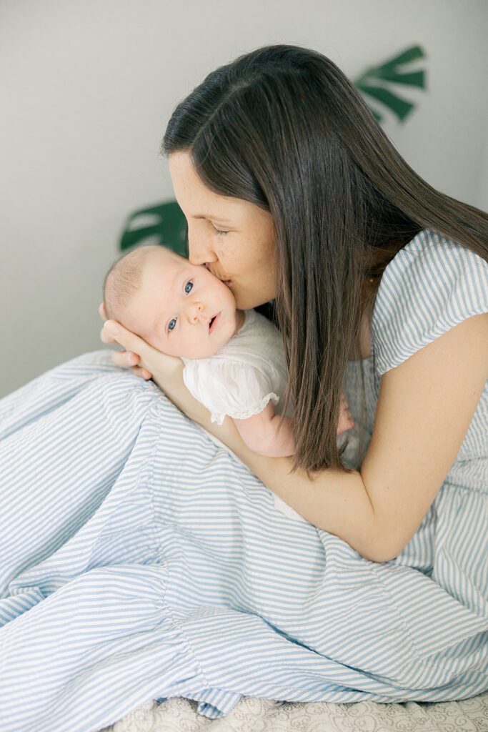a mother kissing a 6 week old baby